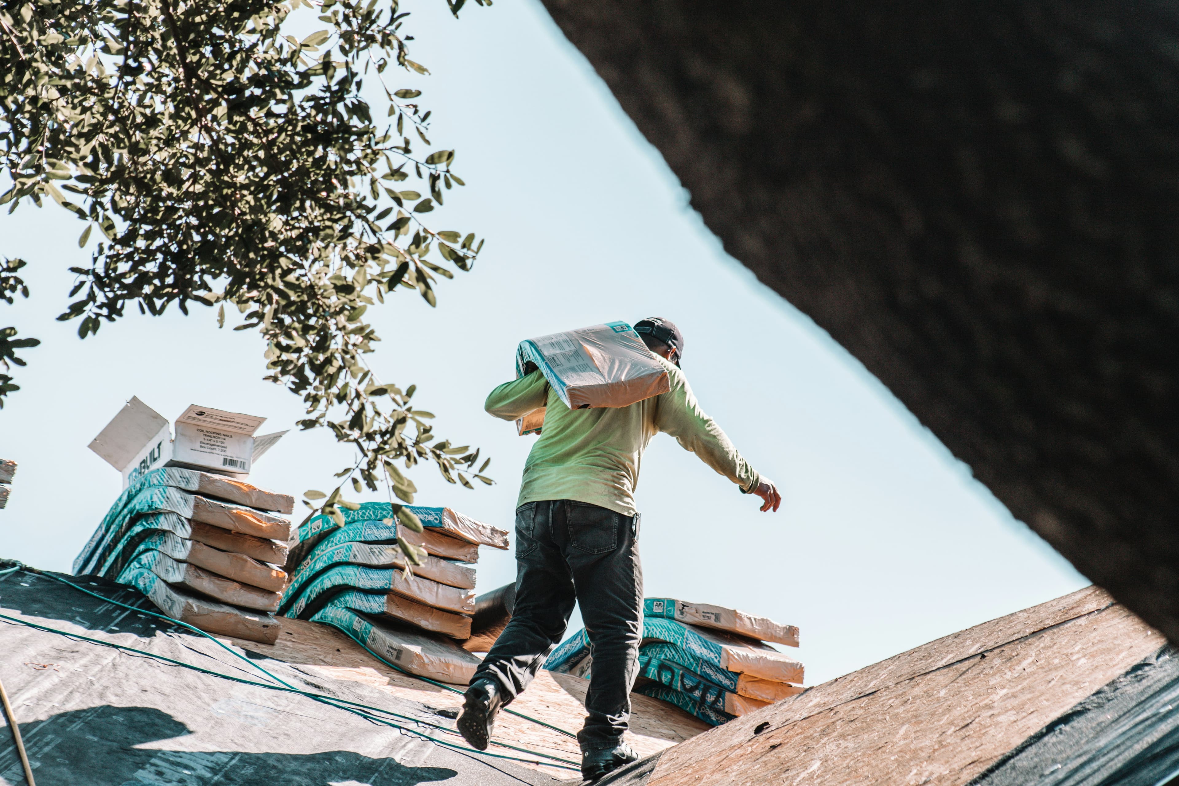 Roofer carrying materials on a roof